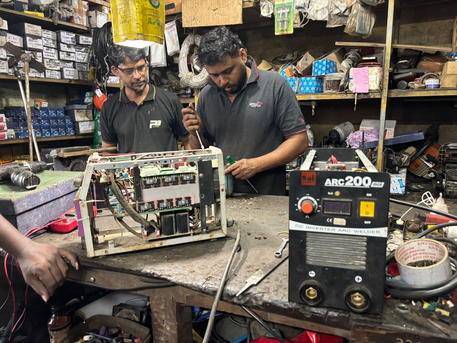 Technicians repairing an inverter welding machine on the workbench